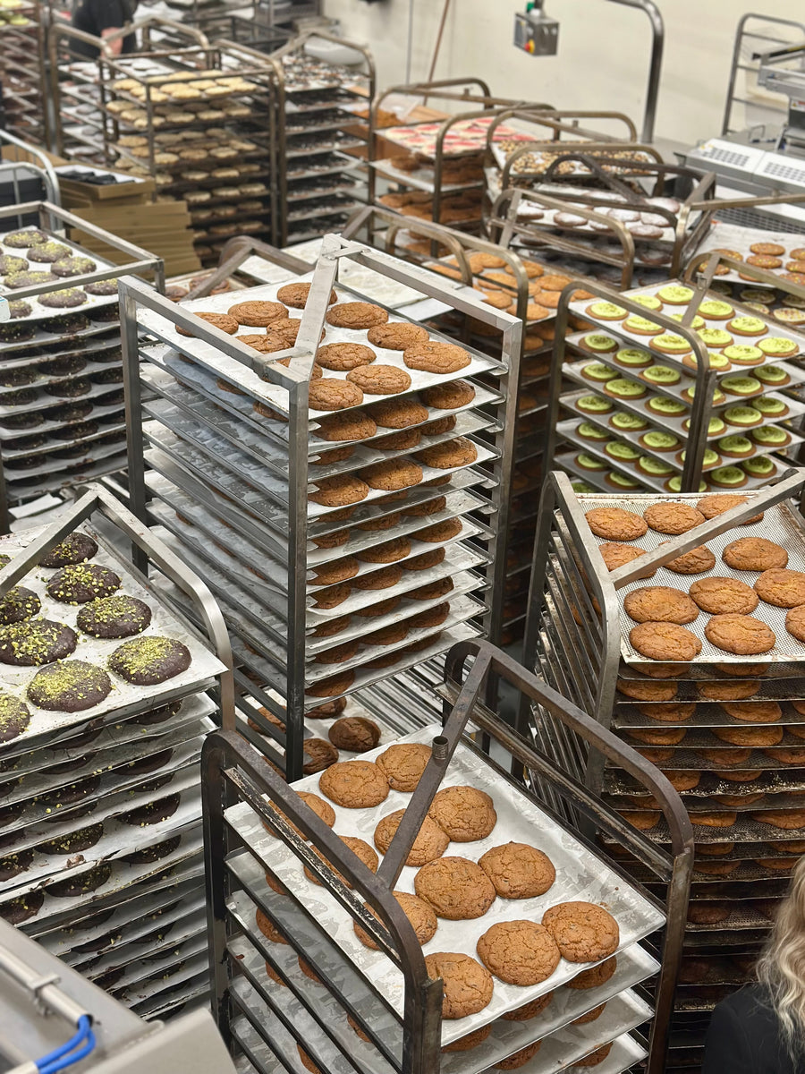Plåtar med cookies på bagerivagnar under produktionen hos Ejvinds